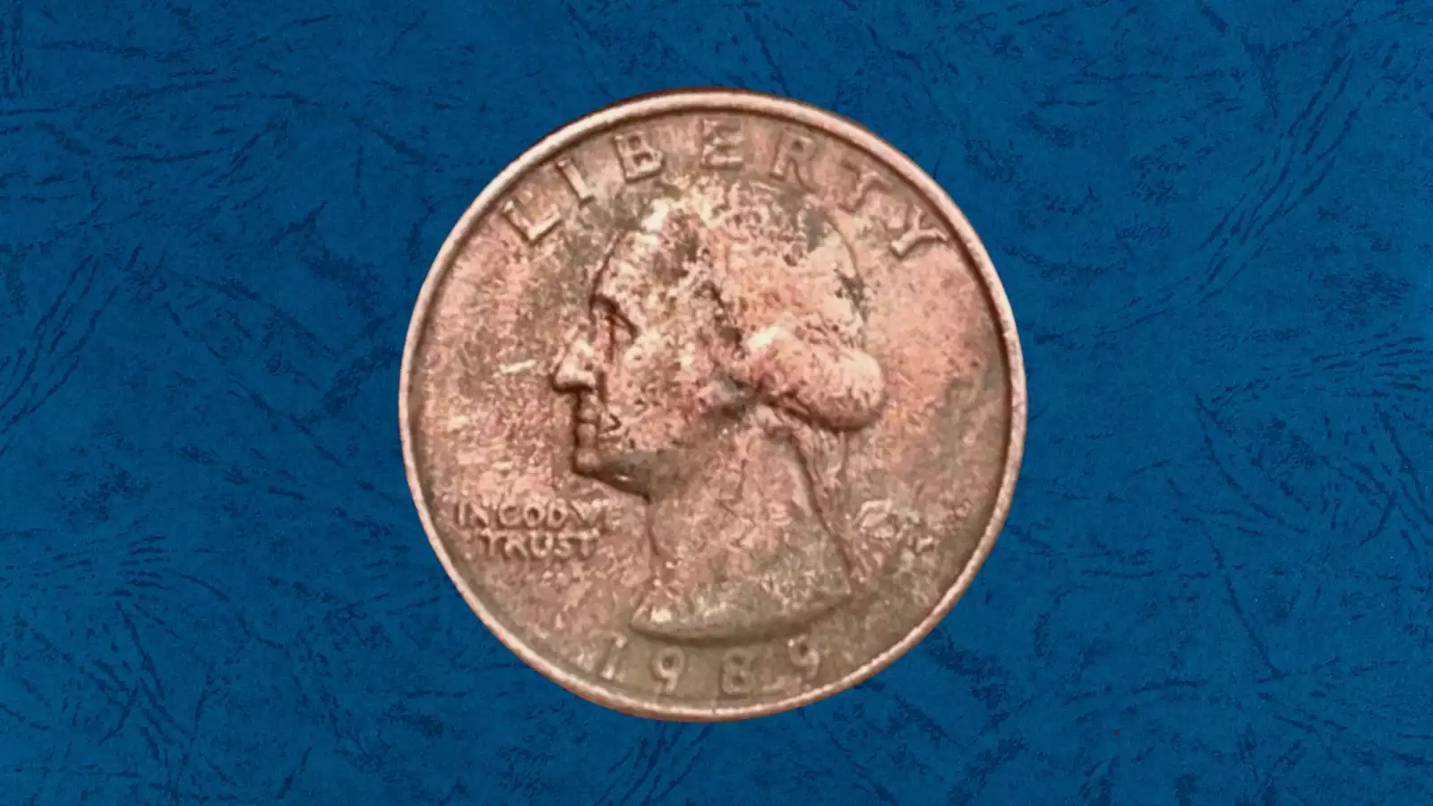 1989 quarter missing obverse clad layer showing copper-colored Washington portrait surface